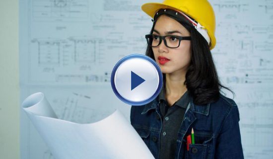 A woman in a hard hat holding papers.