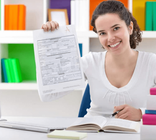 A woman holding up an exam paper in front of her face.