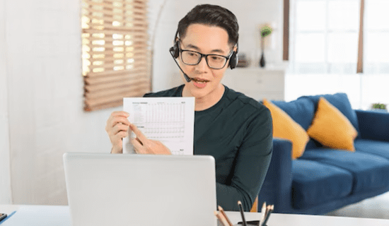 A woman sitting at her desk looking at the paper.